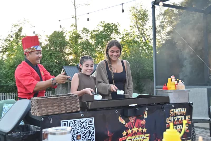 2 girls helping hibachi chef cook